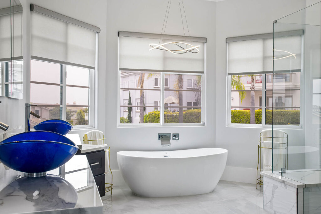 Large bright bathroom with tub and big windows.