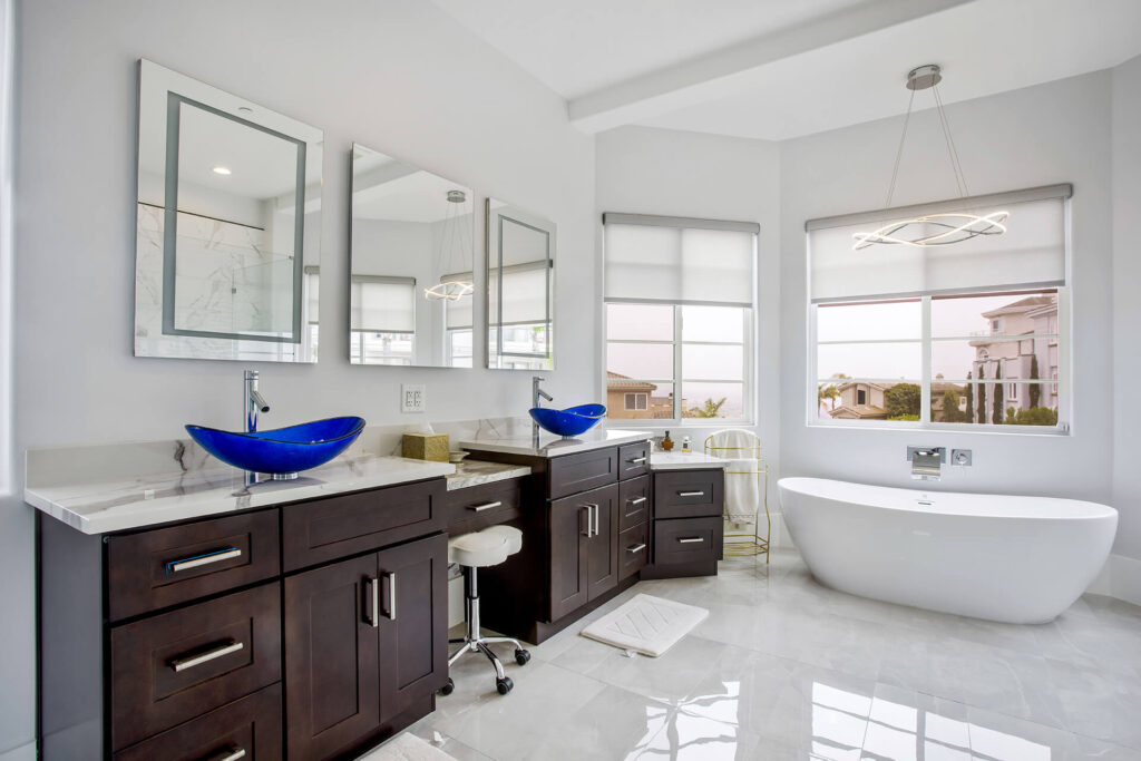 Modern bathroom with blue vessel sinks and white bathtub.