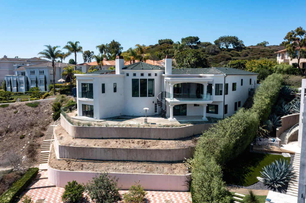 Large modern house with spiral staircase and large windows.