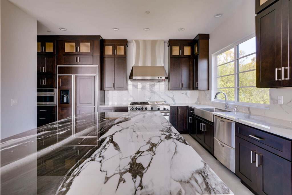 Large kitchen with dark cabinets and marble countertops