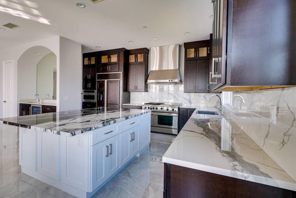 Large kitchen with dark wood cabinets and white marble countertops.