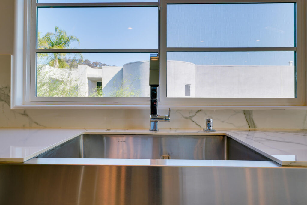 View of a modern kitchen sink and window.