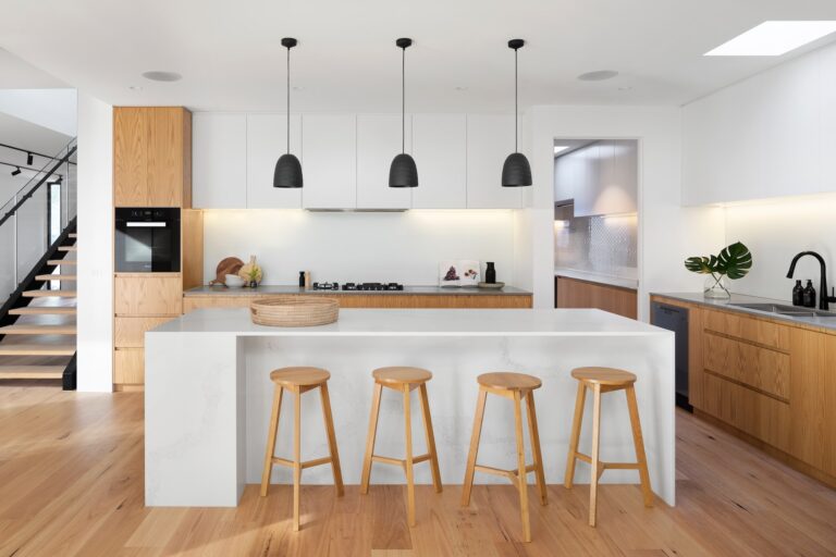 Modern kitchen with wood cabinets and white countertops.