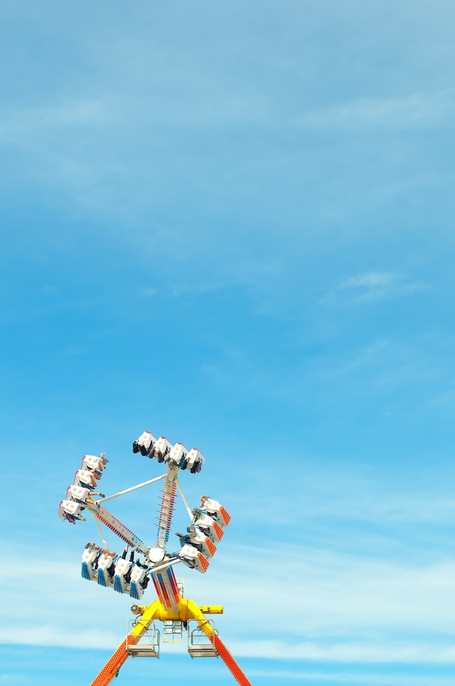 A carnival swing ride against the blue sky.