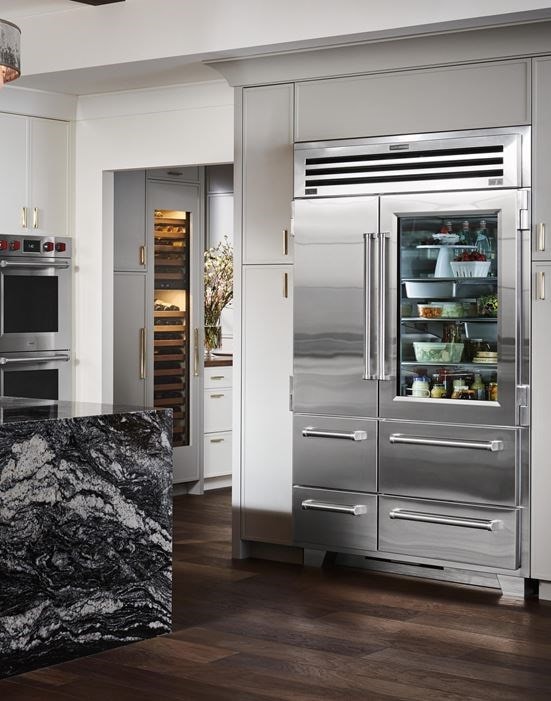 A stainless steel refrigerator with glass door and freezer drawers.